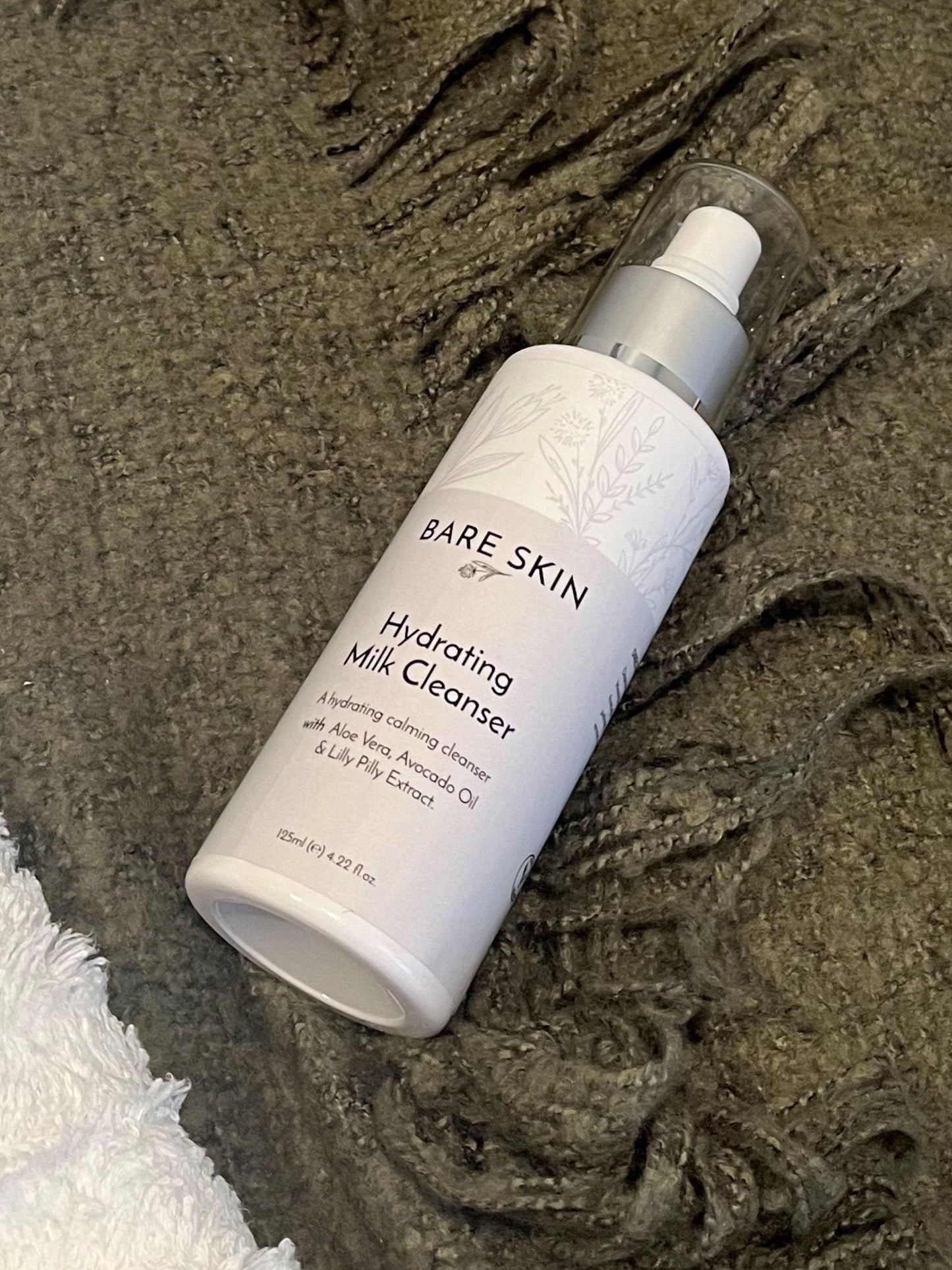 Bare Skin Hydrating Milk Cleanser bottle on a textured surface