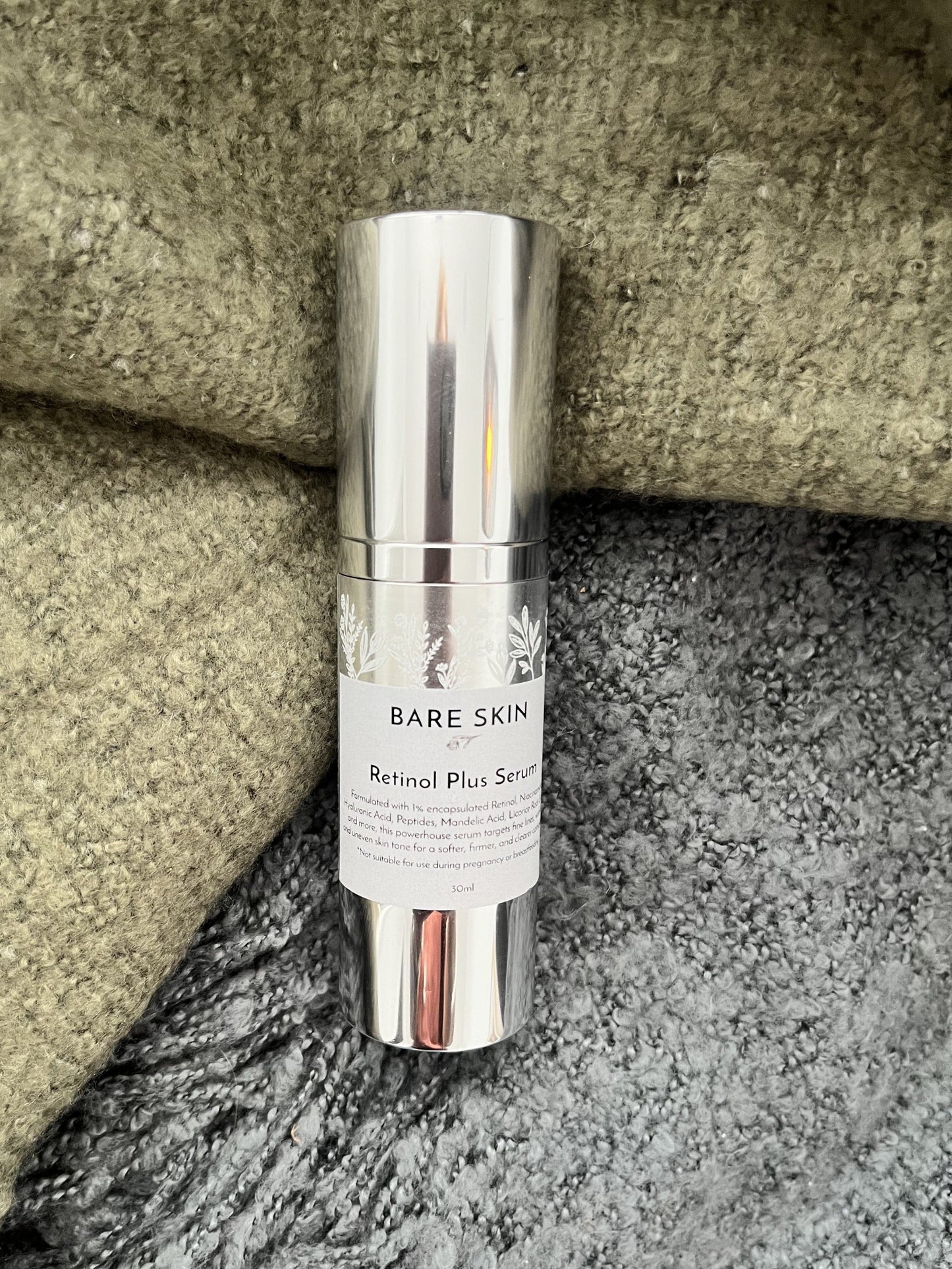 Bare Skin Retinol Plus Serum bottle on a stone surface