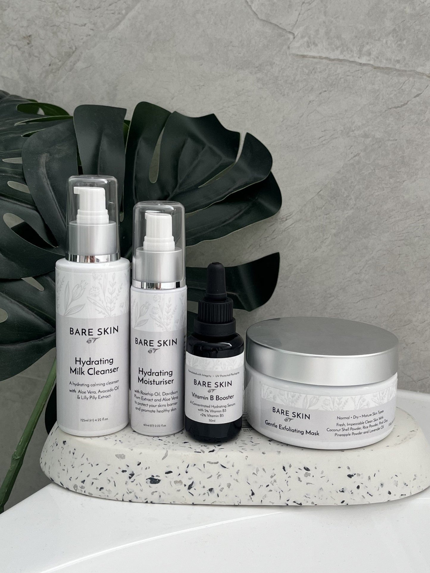 Bare Skin Teen Hydration Skin Kit products on stone surface with grey wall and plant in background, starter skincare routine for healthy clear skin