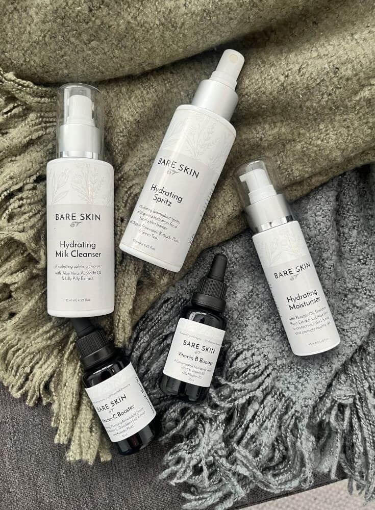 Collection of Bare Skin hydrating skincare products on a textured fabric