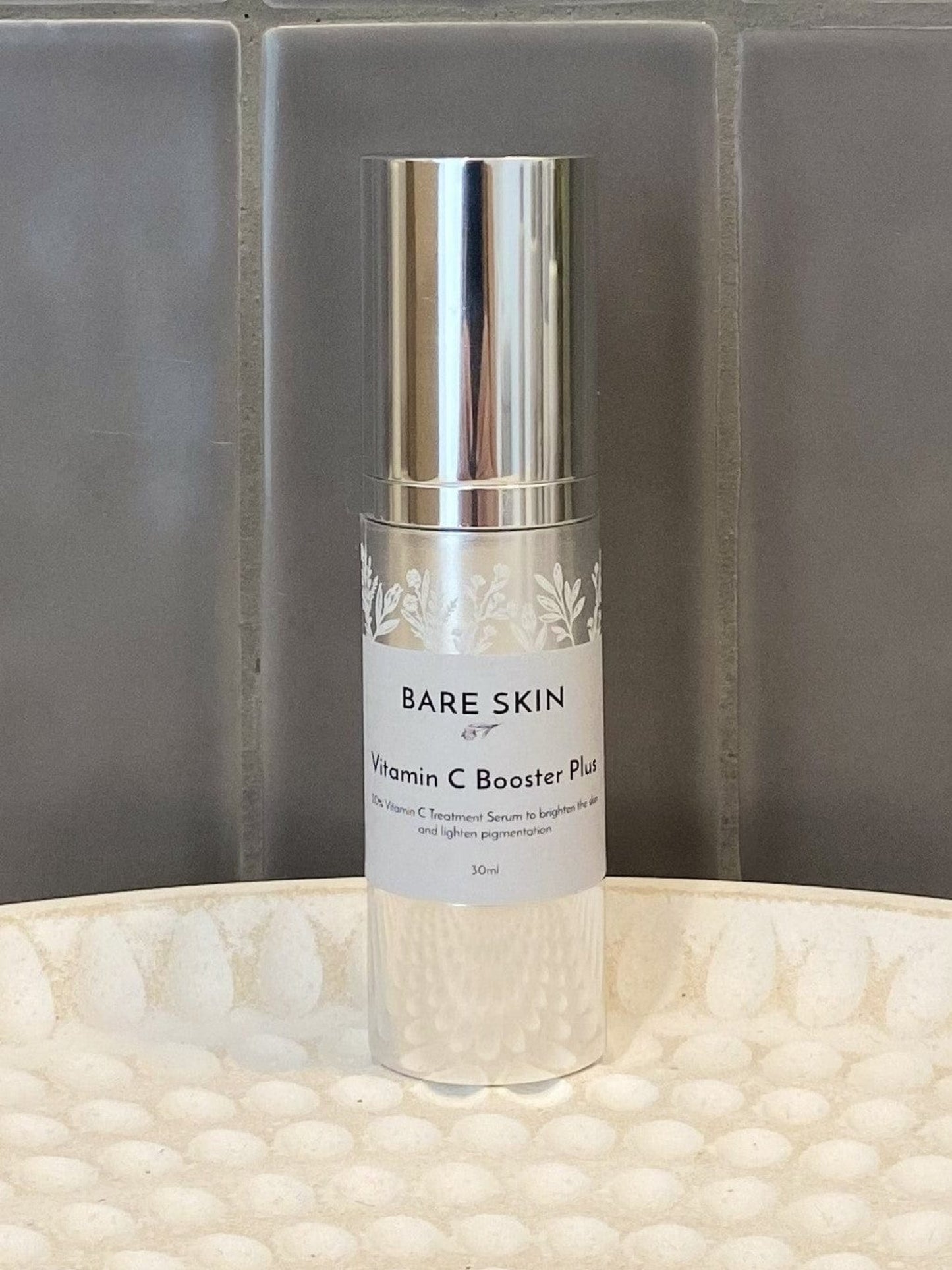 Bare Skin Vitamin Booster sitting on a textured surface.