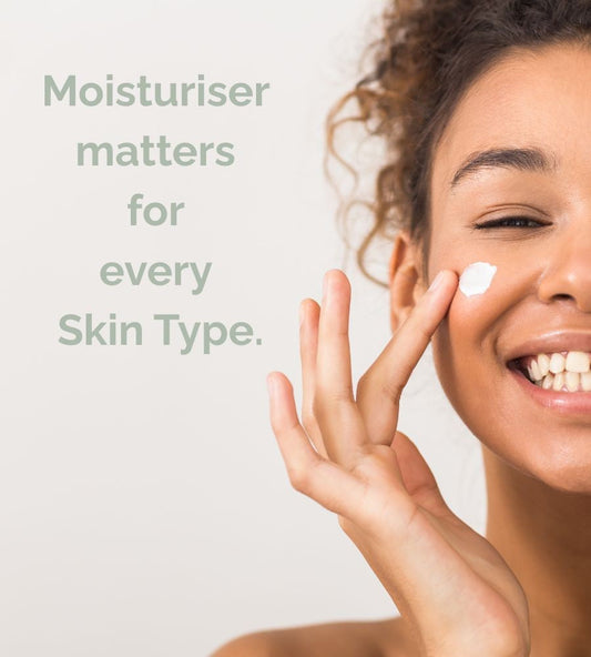 A lady smiling applying a moisturiser to her skin.
