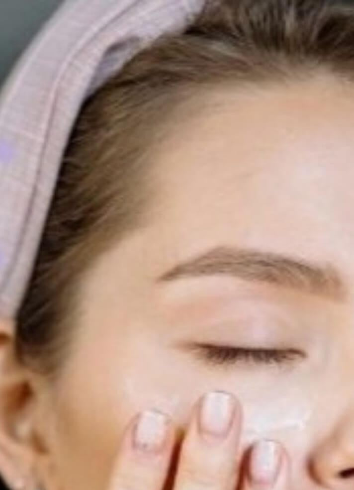 Close-up of woman with Bare Skin Cooling Eye Gel dotted under eye, aloe vera cucumber and green tea formula for puffiness and hydration.