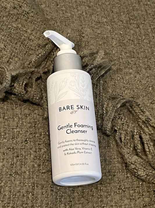 Bare Skin Gentle Foaming Cleanser bottle laying on a green blanket