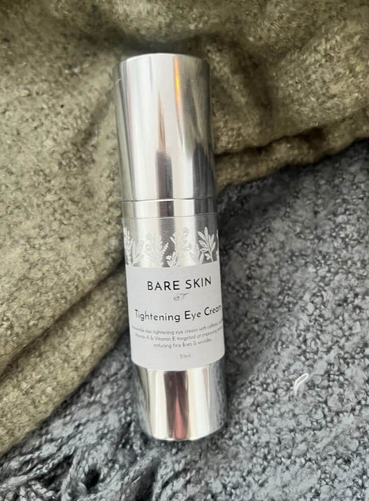 Bottle of Bare Skin Tightening Eye Cream laying on a green and grey blanket