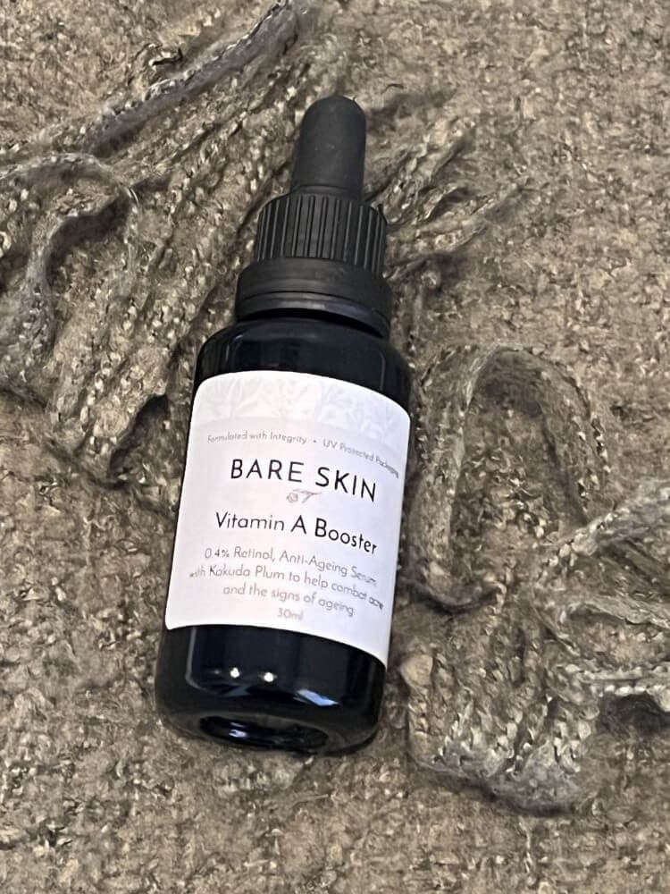 Bare Skin Vitamin A Booster encapsulated retinol serum for sensitive skin bottle on green blanket, gentle anti-aging skincare.