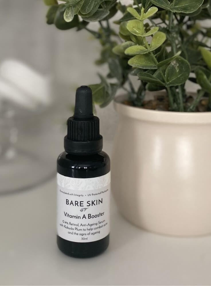 Bare Skin Vitamin A Booster encapsulated retinol serum for sensitive skin bottle on surface with plant in background, barrier-friendly anti-aging serum.