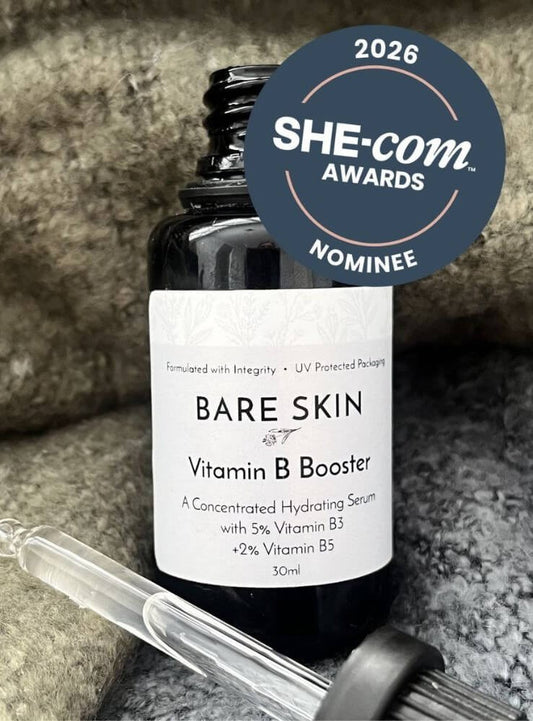 Bottle of Bare Skin Vitamin B Booster serum with dropper on a textured surface, 2026 SHE-com Awards Nominee badge visible.